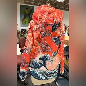 Orange, blue and cream colored sweat shirt